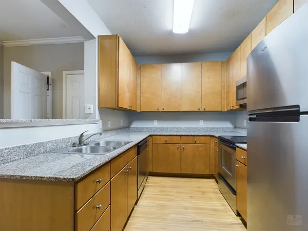 a kitchen with granite countertop a sink and cabinets