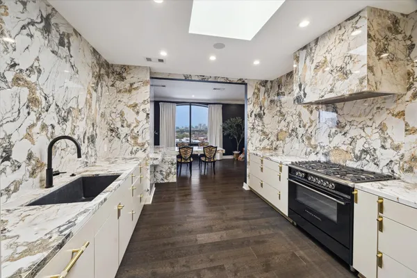 a kitchen with granite countertop white cabinets and stainless steel appliances