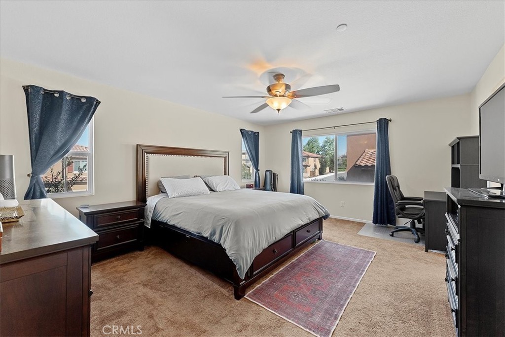 10969 Elkwood Circle Riverside, CA 92503 - Photo 15 of 42 a spacious bedroom with a bed and a flat screen tv