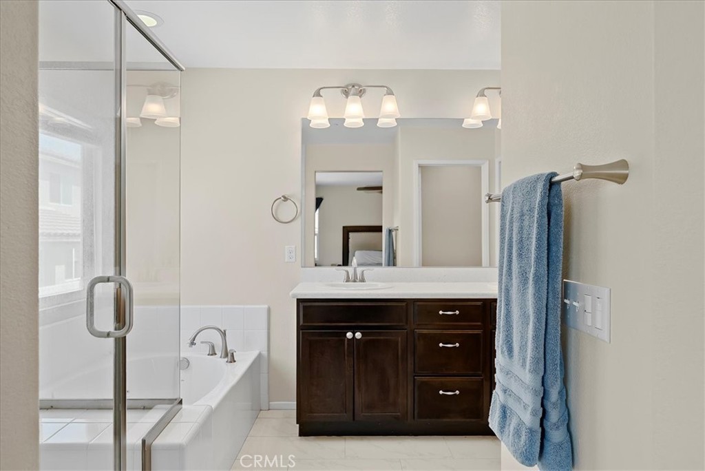 10969 Elkwood Circle Riverside, CA 92503 - Photo 17 of 42 a bathroom with a sink a mirror and a shower
