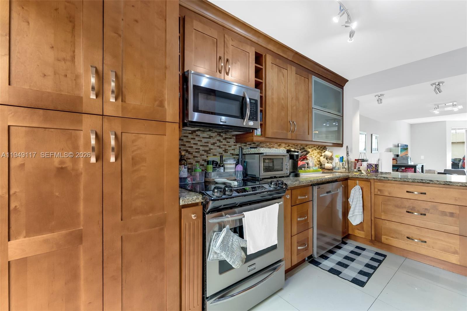 7858 Southwest 102nd Lane Miami, FL 33156 - Photo 4 of 22 a kitchen with stainless steel appliances granite countertop a sink stove and refrigerator