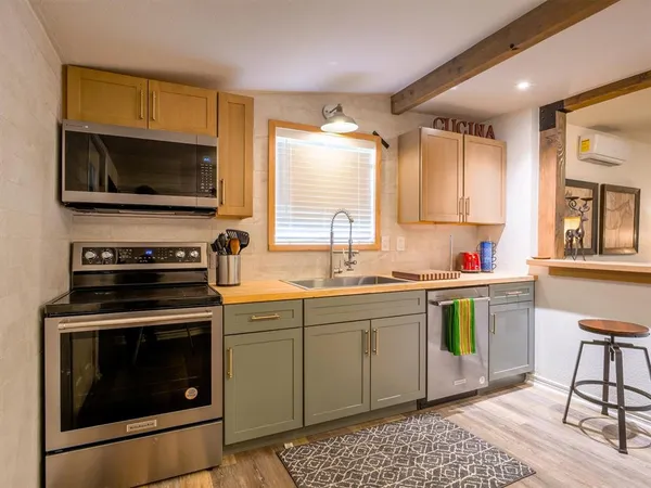 a kitchen with a stove a sink and a microwave