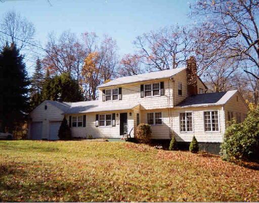 16 Mead Ridge Road Ridgefield, CT 06877 - Photo 1 of 1 a front view of a house with a yard and trees