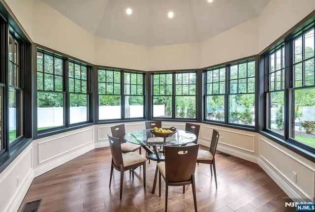 a dining room with furniture window wooden floor and garden view