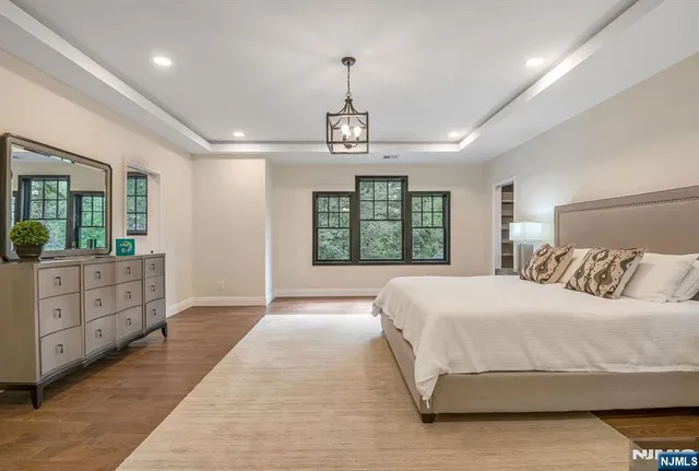 a spacious bedroom with a large bed and a dresser