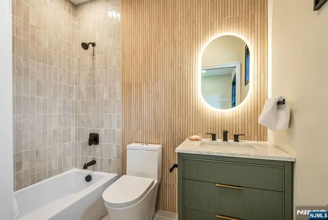 a bathroom with a toilet sink vanity tub and shower