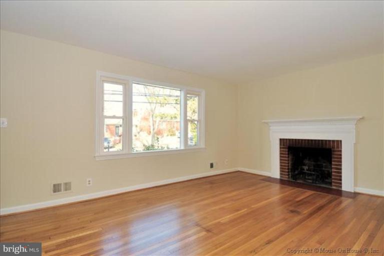 602 Lanark Way Silver Spring, MD 20901 - Photo 3 of 24 an empty room with wooden floor fireplace and windows