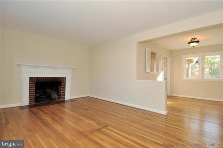 602 Lanark Way Silver Spring, MD 20901 - Photo 4 of 24 an empty room with wooden floor and a fireplace
