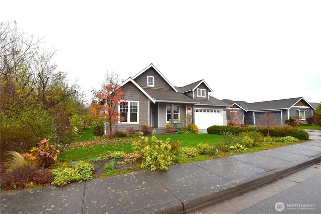 a front view of a house with a yard and potted plants