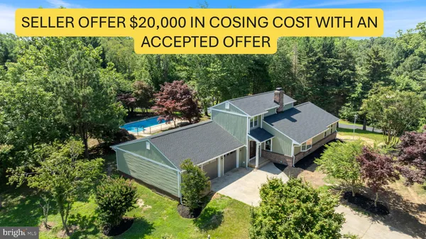aerial view of a house with a yard and trees