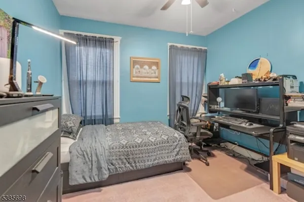 a bedroom with a bed and a flat tv screen on a dresser