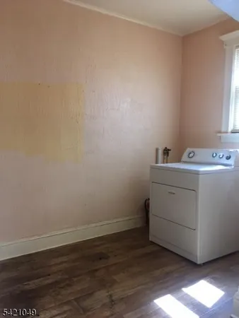 a utility room with wooden floor washer and dryer
