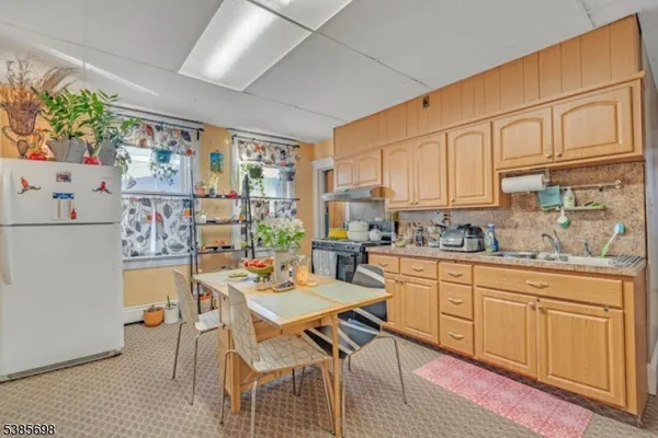a kitchen with stainless steel appliances granite countertop a dining table chairs sink and cabinets
