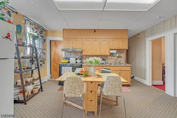 a view of a dining room with furniture and a kitchen view