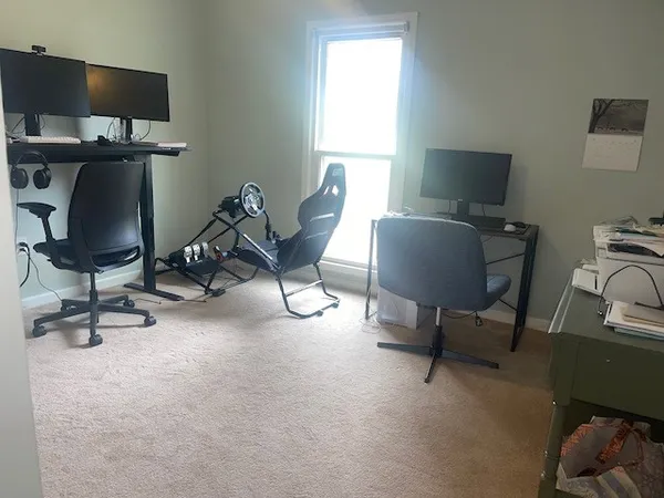 a view of a workspace with furniture and a window