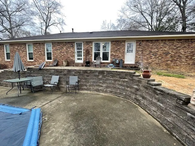 a view of a house with backyard sitting area and garden