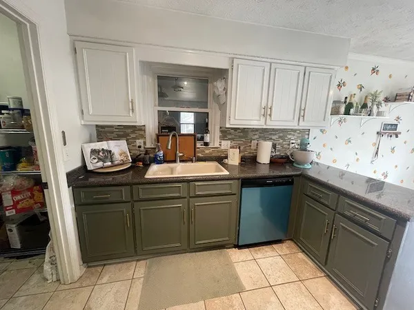 a kitchen with a sink window and cabinets