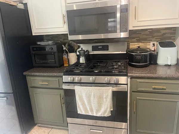 a kitchen with stainless steel appliances granite countertop a stove and a microwave