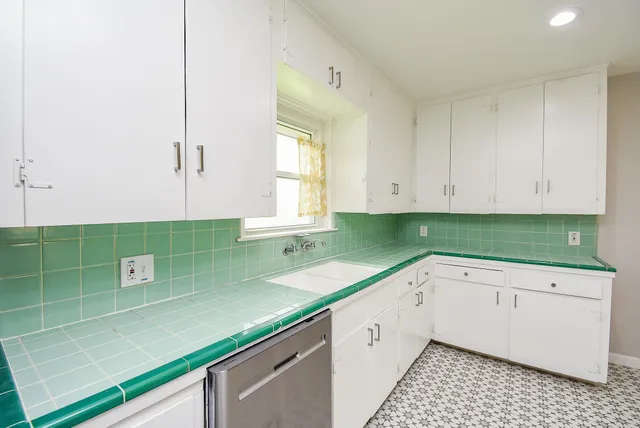 a kitchen with a sink a counter top space and cabinets
