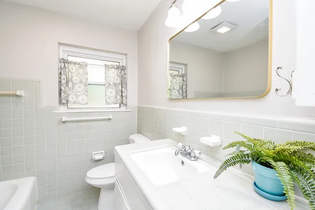 a bathroom with a sink a toilet and a mirror