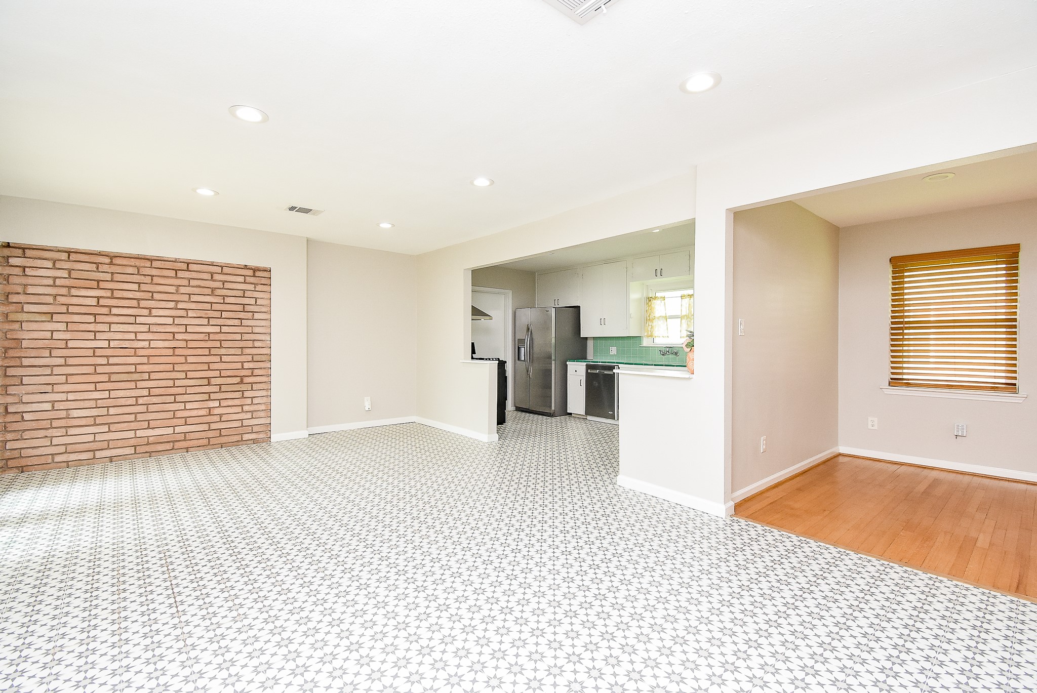 7901 Ridgeview Drive Houston, TX 77055 - Photo 7 of 37 a view of an empty room with wooden floor and a kitchen