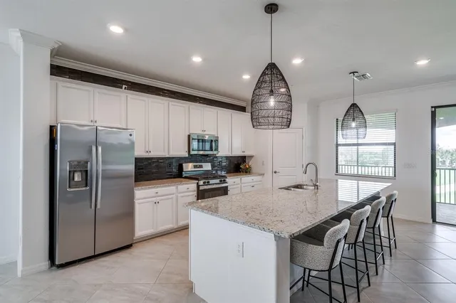 a kitchen with granite countertop a sink stainless steel appliances and cabinets