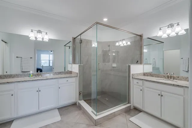 a bathroom with a sink a toilet a large mirror and shower