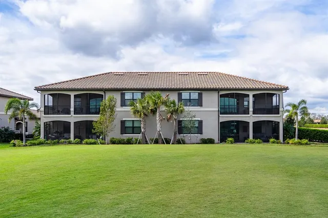 a front view of a house with a garden and tree