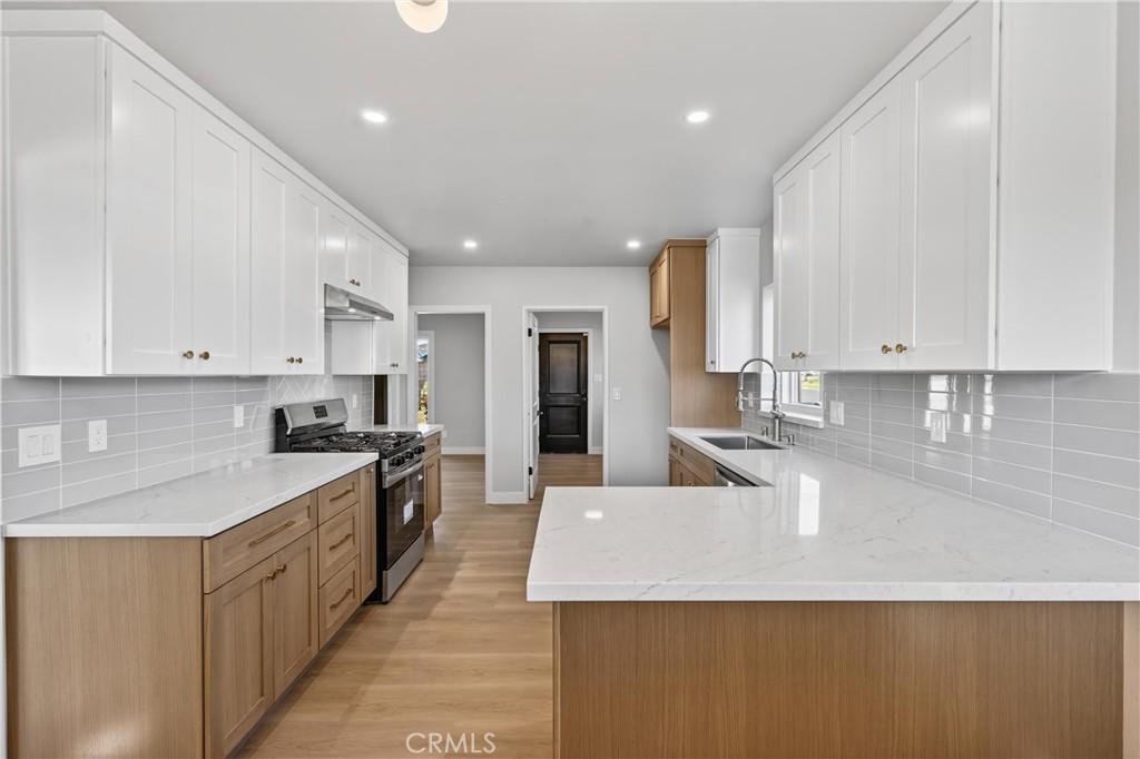 942 North Encina Avenue Rialto, CA 92376 - Photo 14 of 49 a large kitchen with kitchen island a sink a stove and refrigerator