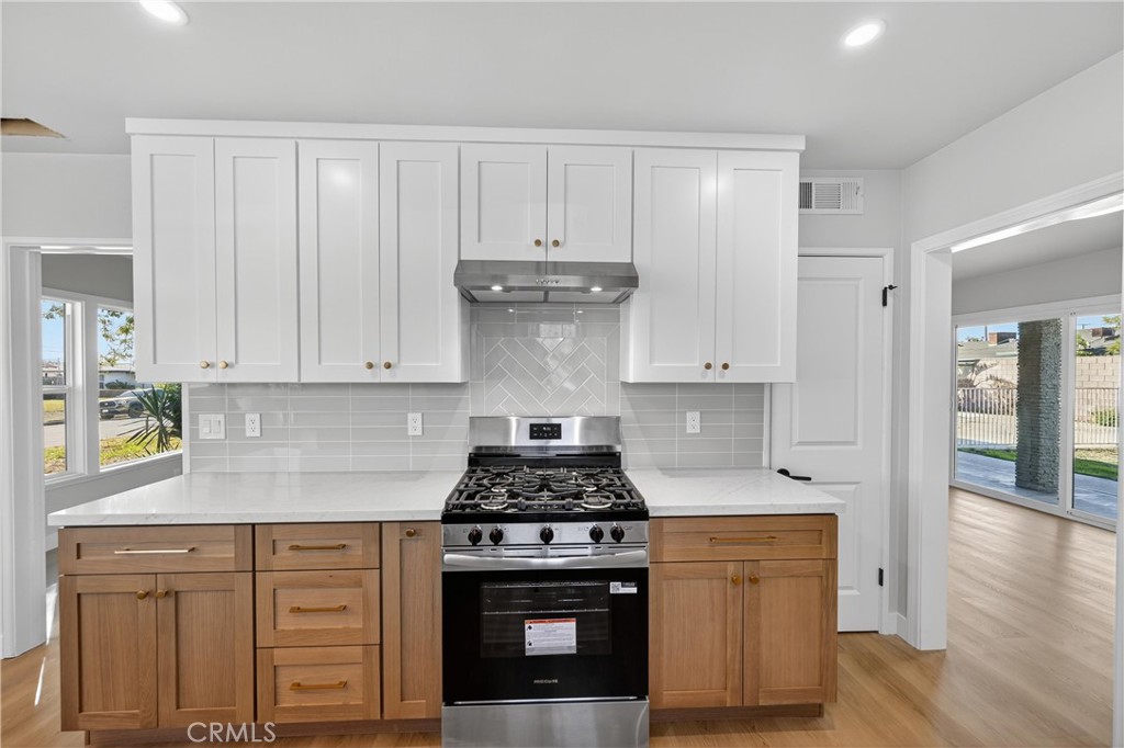 942 North Encina Avenue Rialto, CA 92376 - Photo 18 of 49 a kitchen with granite countertop white cabinets and stainless steel appliances