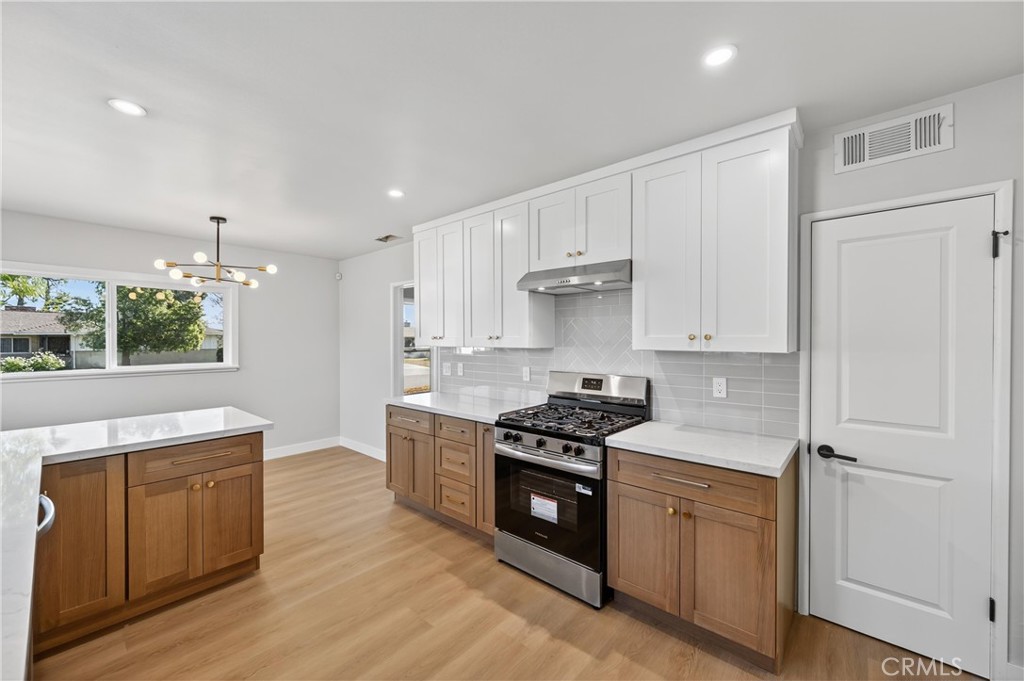 942 North Encina Avenue Rialto, CA 92376 - Photo 19 of 49 a kitchen with stainless steel appliances a stove a sink and a refrigerator