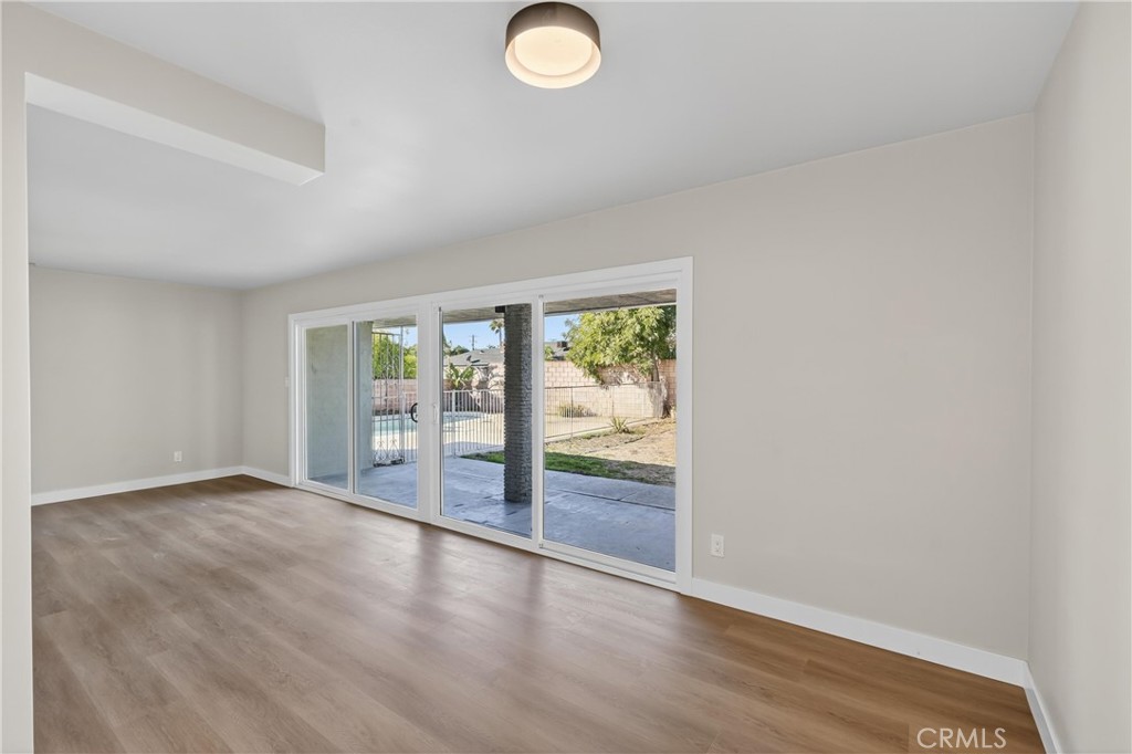 942 North Encina Avenue Rialto, CA 92376 - Photo 22 of 49 an empty room with wooden floor and windows
