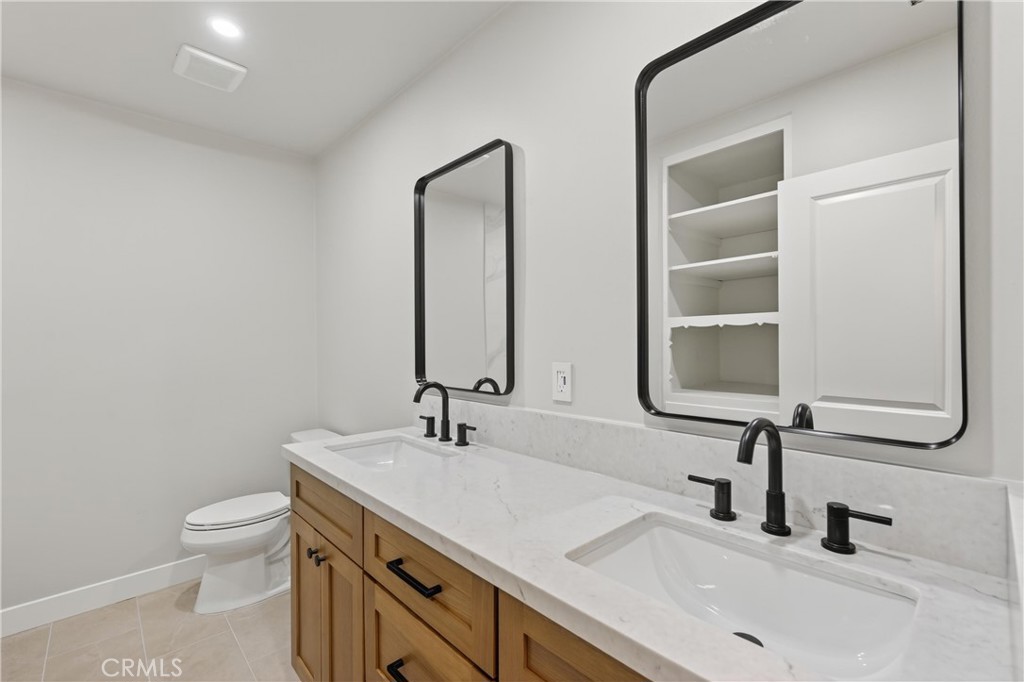 942 North Encina Avenue Rialto, CA 92376 - Photo 37 of 49 a bathroom with a double vanity sink toilet and mirror