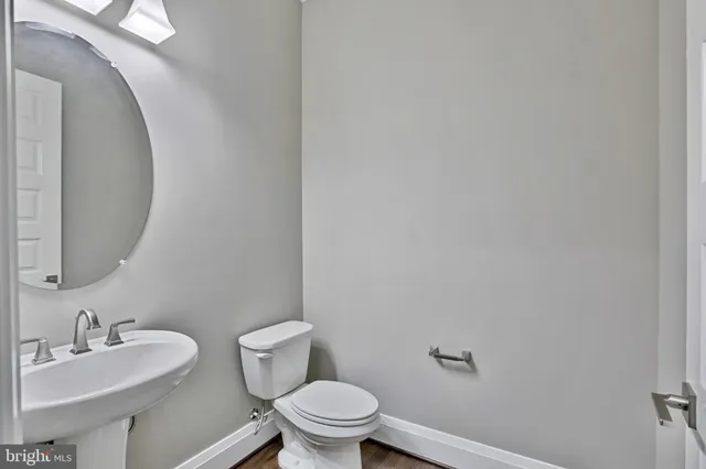 a bathroom with a toilet a sink and mirror