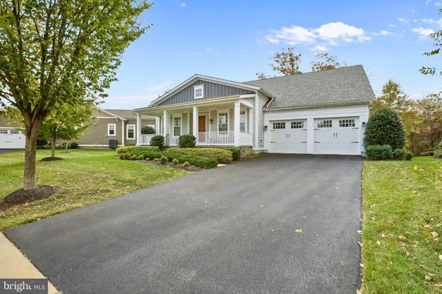 a front view of a house with a garden and trees