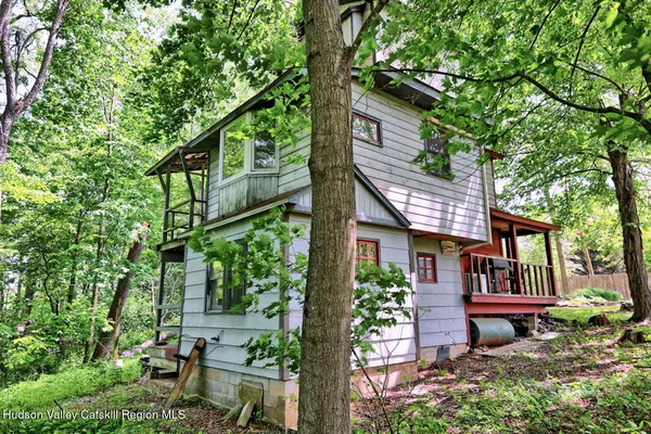 a backyard of a house with table and chairs under an umbrella