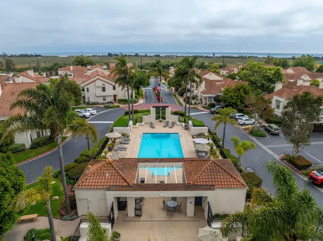 an aerial view of residential houses with outdoor space and ocean view