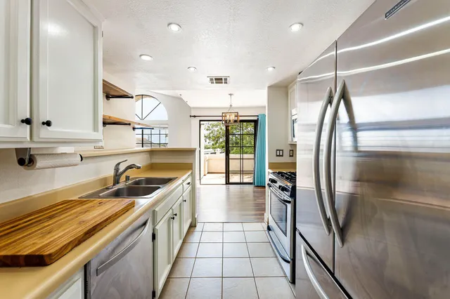 a kitchen with a sink a counter top space stainless steel appliances and cabinets