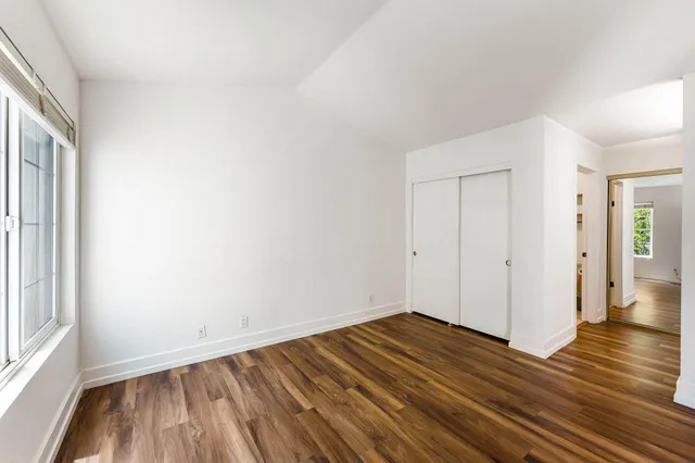 a view of a room with wooden floor and white walls
