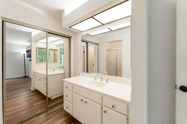 a bathroom with a sink mirror and a shower