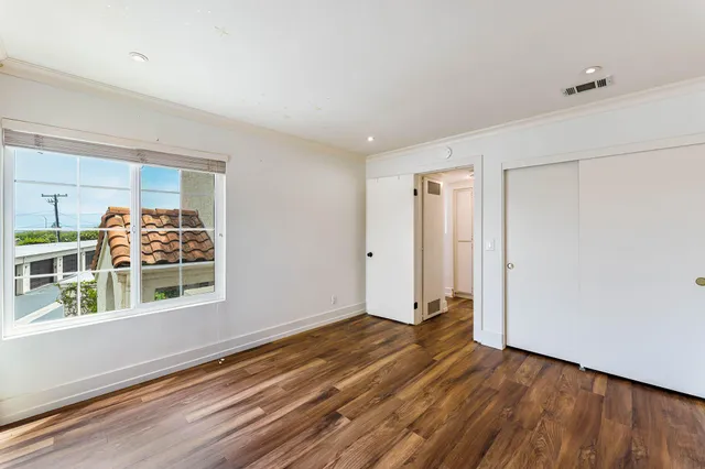 a view of a big room with wooden floor and windows