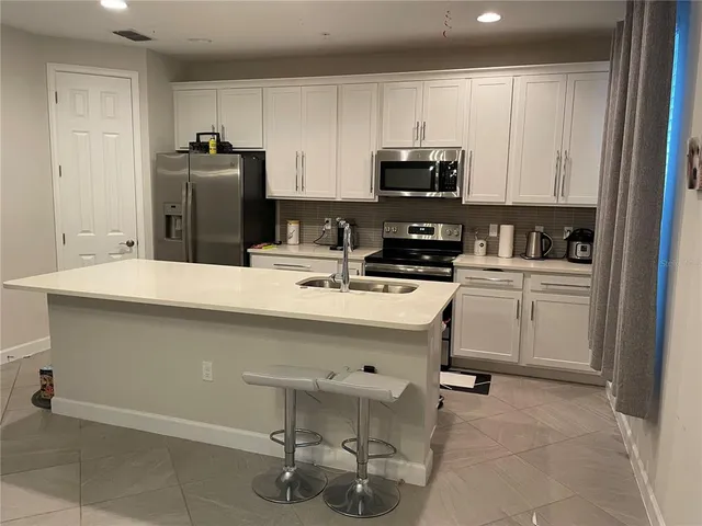 a kitchen with a sink refrigerator and cabinets