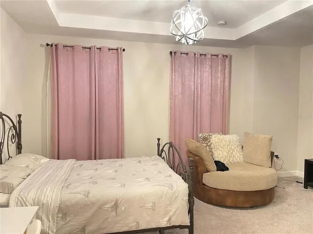 a bedroom with a bed and a chandelier