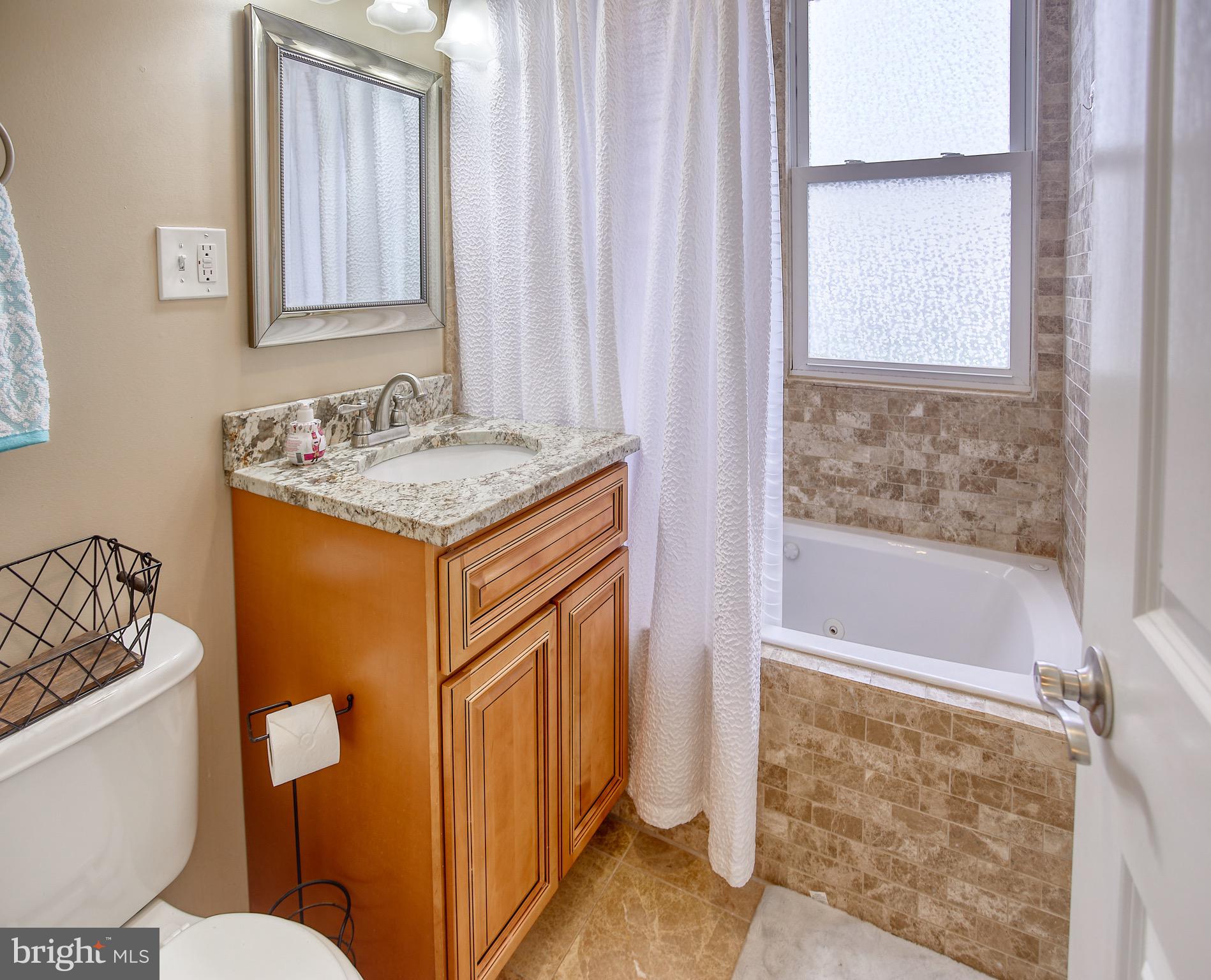 8220 Longpoint Road Dundalk, MD 21222 - Photo 16 of 22 a bathroom with a granite countertop sink and a toilet