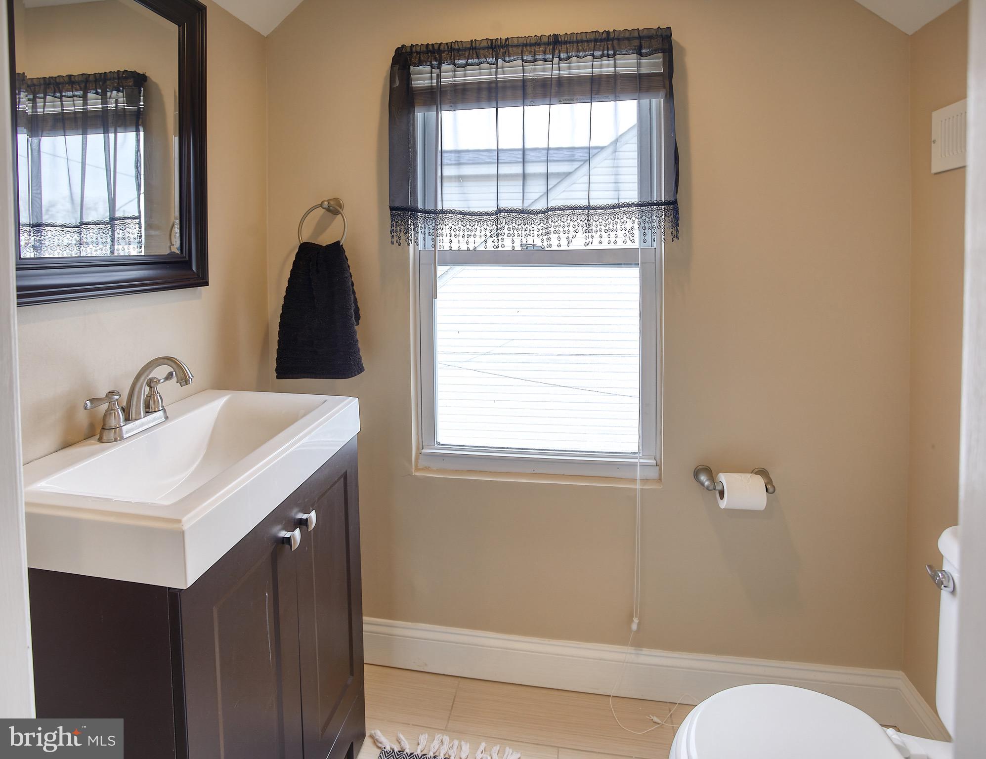 8220 Longpoint Road Dundalk, MD 21222 - Photo 22 of 22 a bathroom with a sink a toilet and window
