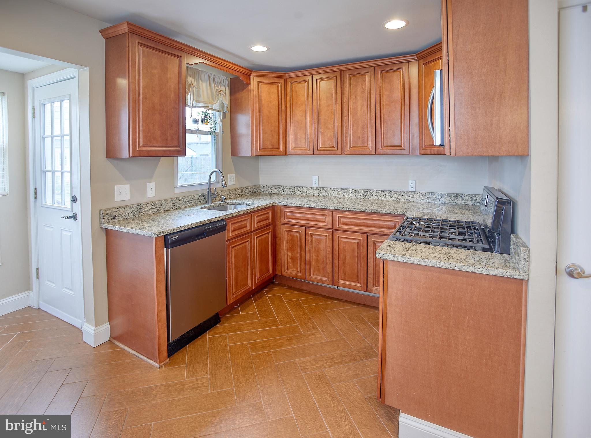 8220 Longpoint Road Dundalk, MD 21222 - Photo 10 of 22 a kitchen with stainless steel appliances granite countertop a stove a sink and a microwave