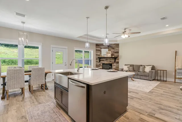 a open kitchen with stainless steel appliances granite countertop a sink a stove and a wooden floors