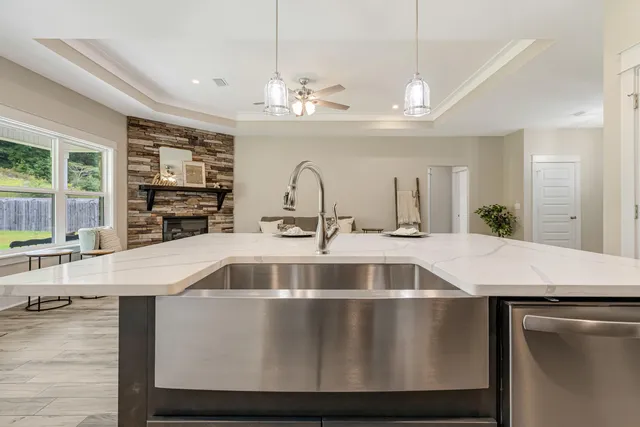 a view of a kitchen with kitchen island a sink stainless steel appliances and cabinets