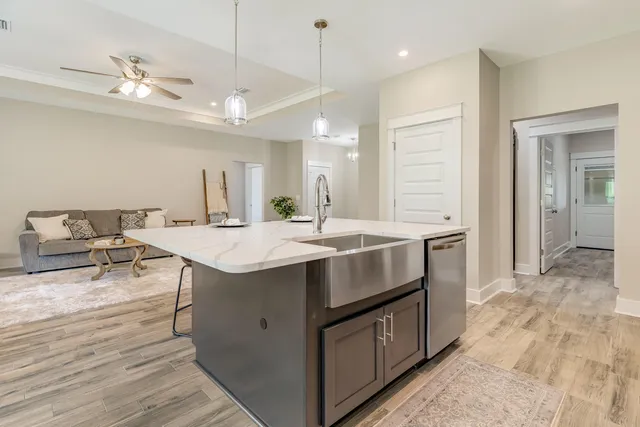 a kitchen with kitchen island a sink stove and wooden floor