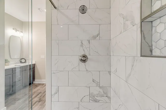 a bathroom with shower sink and mirror